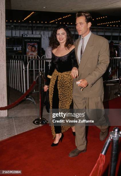 American actress Fran Drescher, wearing a black outfit with a leopard print wrap skirt, and her husband, American actor Peter Marc Jacobson, who...