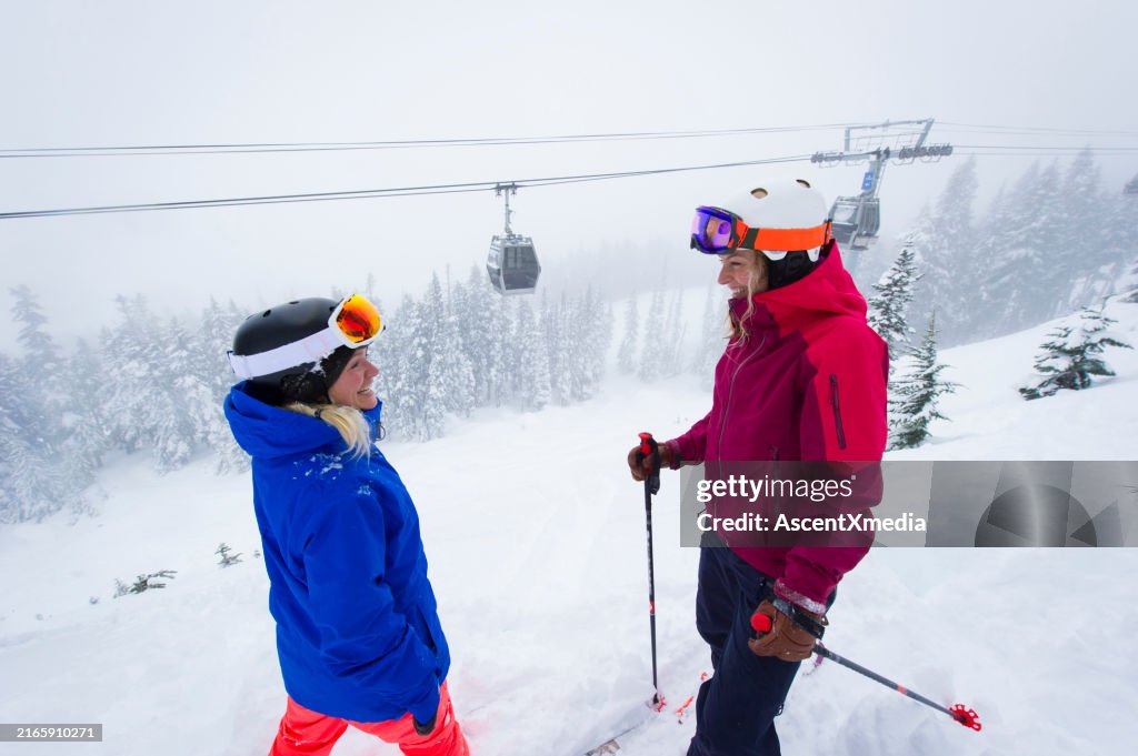 Friends pause on ski hill on snowy day