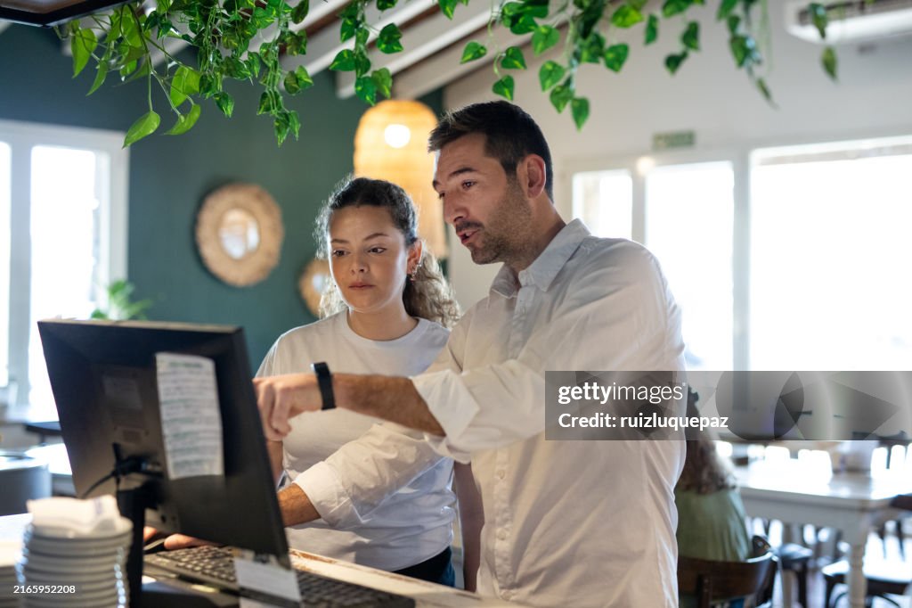 Young woman on her first day of work learning in a coffee shop