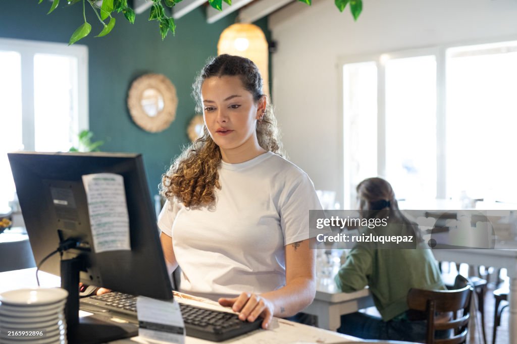 Young woman on her first day of work learning in a coffee shop