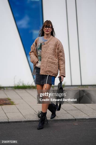 Guest wears black sunglasses, light gray brown tree pattern/print sweater vest, light brown pattern oversized quilted jacket, black and navy blue...