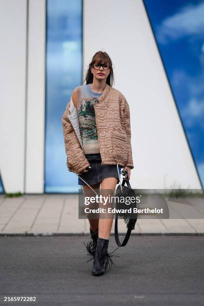 Guest wears black sunglasses, light gray brown tree pattern/print sweater vest, light brown pattern oversized quilted jacket, black and navy blue...