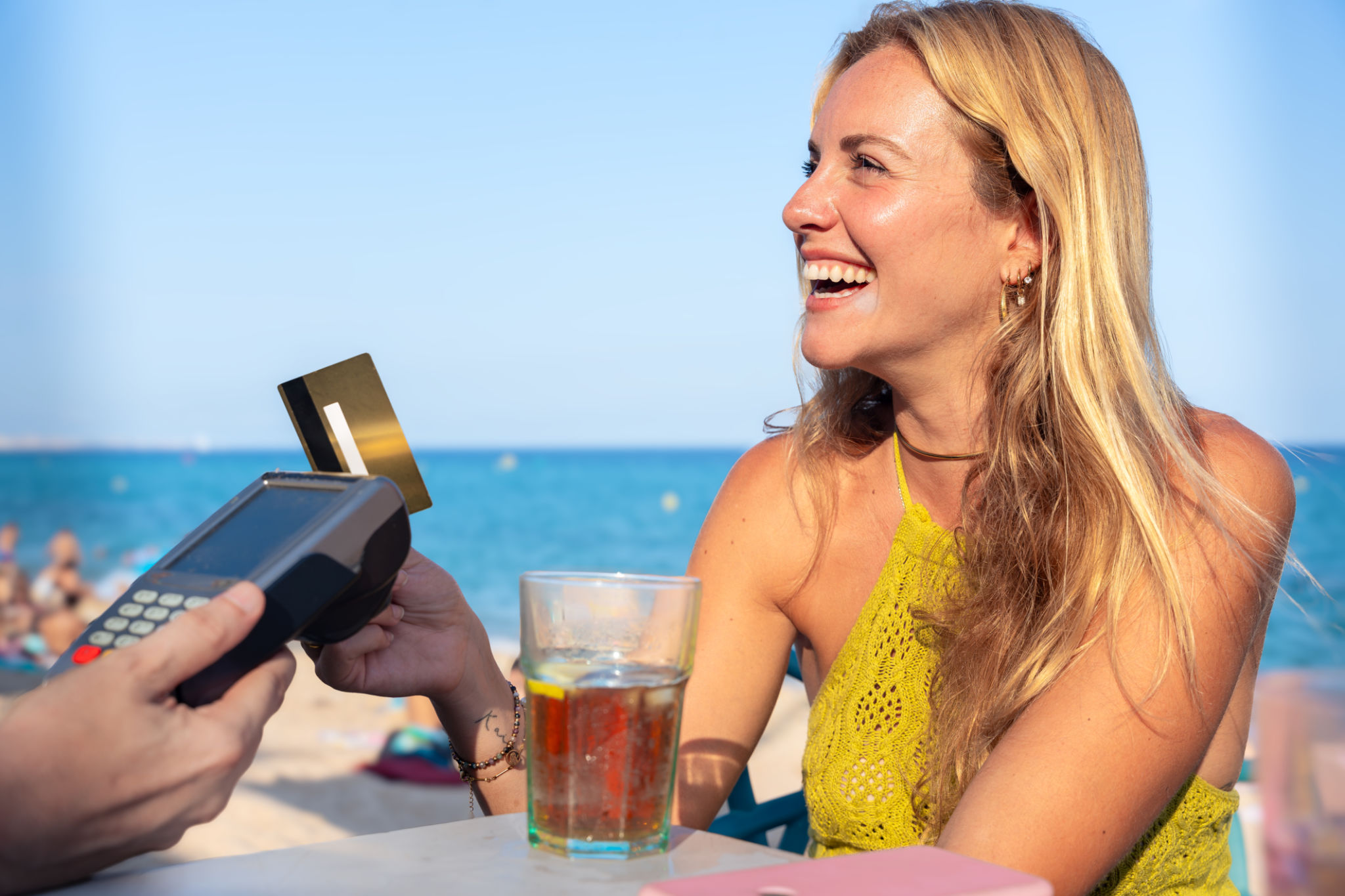 Smiling woman customer paying with contactless credit card in a restaurant. Smiling woman customer paying with contactless credit card in a restaurant.