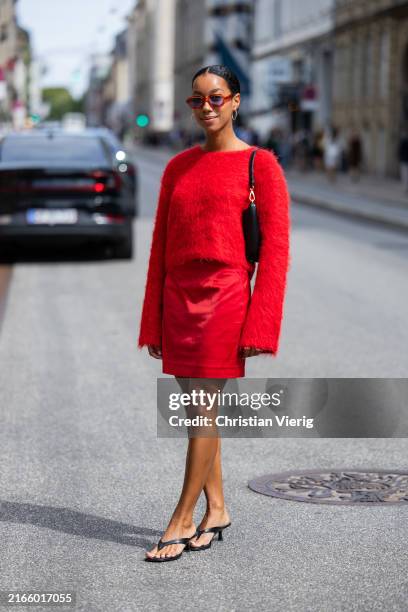 Amaka Hamelijnck wears red wool, skirt, black bag outside Gestuz during day four of the Copenhagen Fashion Week SS25 on August 08, 2024 in...