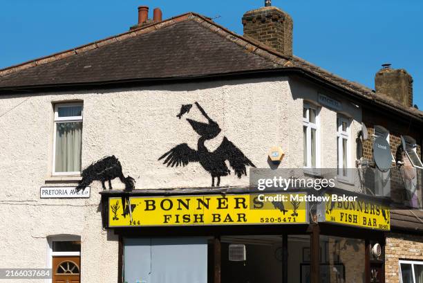 Mural purportedly by the artist Banksy, showing pelicans eating fish, adorns the side of Bonners fish and chip shop on August 09, 2024 in...