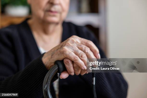 closeup of elderly woman's hands on walking cane - hand holding stick stock pictures, royalty-free photos & images