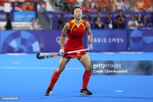 Meirong Zou of Team People's Republic of China reacts after missing her team's seconds penalty in the shootout against Anne Veenendaal of Team...