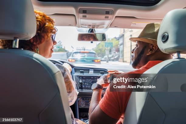 multiracial family city commute: stuck in traffic during a city drive on a sunny day - car point of view stock pictures, royalty-free photos & images