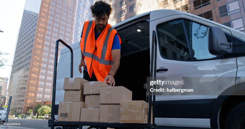 Low Angle Shot of Delivery Person Stacking Boxes on Platform Truck