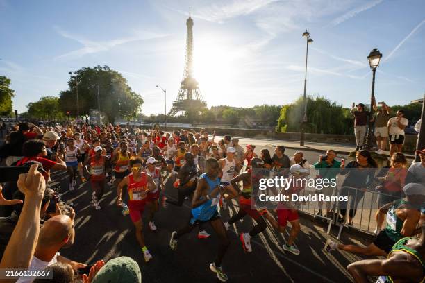 Eliud Kipchoge of Team Kenya, Gabriel Gerald Geay of Team Tanzania, Jie He and Shahoui Yang of Team People's Republic of China run past Eiffel Tower...