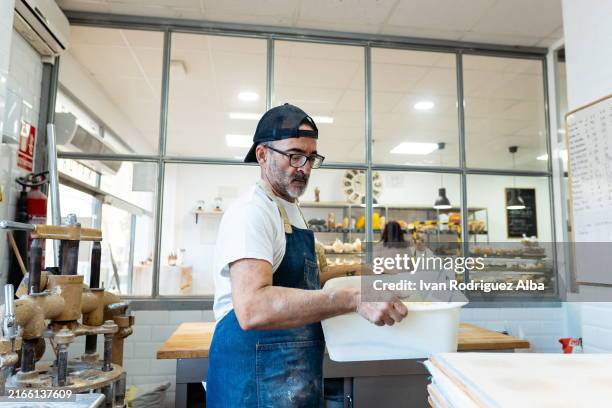 adult baker working in a commercial modern kitchen - condição imagens e fotografias de stock