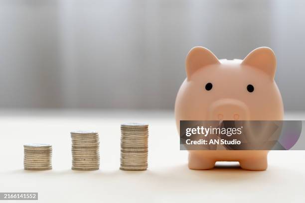 piggy bank and stack of coins money on wooden background. save money for prepare in future and pension retirement. earning interest on savings. growing your wealth and saving money concept - interest rate stock pictures, royalty-free photos & images