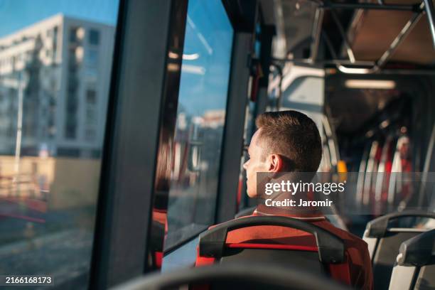 passenger looking out window of tram - nederzettingen stockfoto's en -beelden