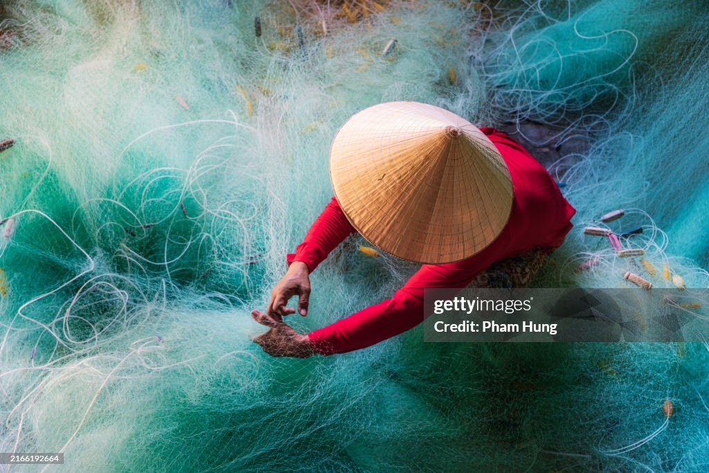 Woman knitting turquoise fishing net net