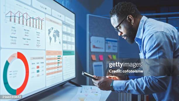 un hombre revisa el análisis de datos del marketing de las plataformas de redes sociales. - auditoría fotografías e imágenes de stock