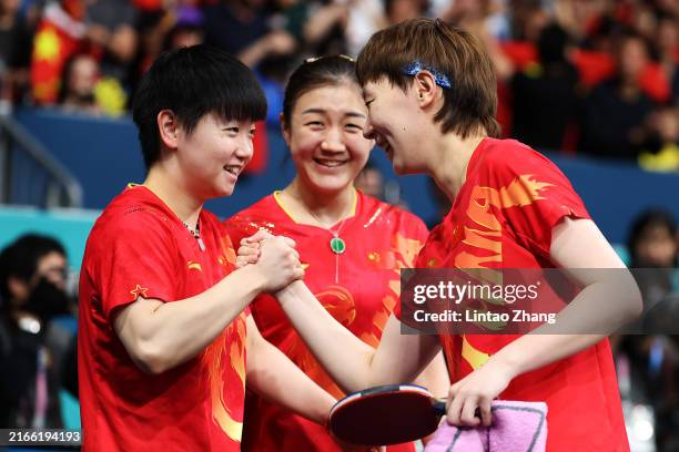 Yingsha Sun, Meng Chen and Manyu Wang of Team People's Republic of China celebrate winning the gold medal after their victory against Team Japan in...