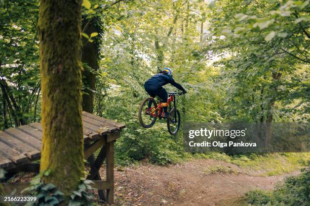 mountain bicyclist on a forest trail on a sunny day, downhill cycling, bicycle - andare in mountain bike foto e immagini stock