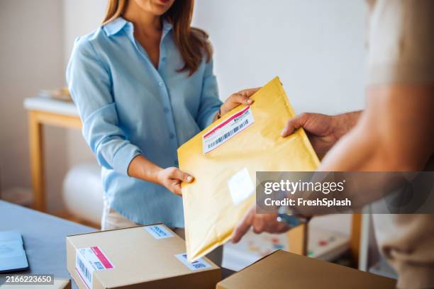 people exchanging package in an office setting - post office stock pictures, royalty-free photos & images