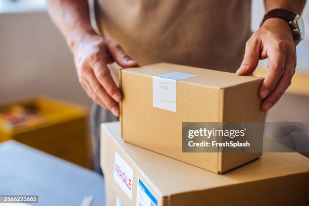 persona que manipula cajas de cartón para el servicio de entrega - oficina de correos fotograf