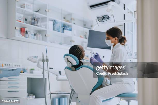 dentist examining patient in modern dental clinic - higiene dental imagens e fotografias de stock