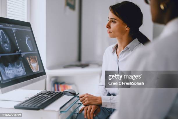 dentist and patient reviewing dental x-rays on computer - scientific imaging technique stock pictures, royalty-free photos & images