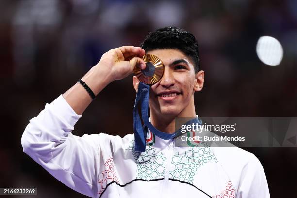 Gold medalist Arian Salimi of Team Islamic Republic of Iran poses on the podium during the Taekwondo medal ceremony after the Men's +80kg on day...