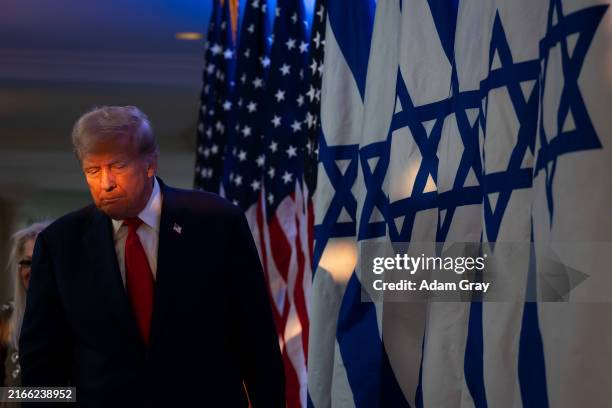 Republican presidential candidate, former U.S. President Donald Trump walks on stage at a fighting anti-semitism event with Miriam Adelson at the...