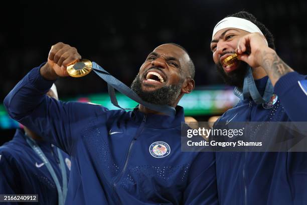 Gold medalists LeBron James and Anthony Davis of Team United States bite their medals while posing for a photo during the Men's basketball medal...
