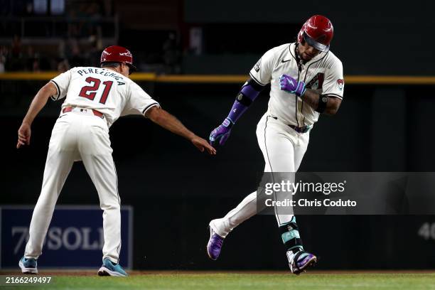 Ketel Marte of the Arizona Diamondbacks high-fives third base coach Tony Perezchica as he rounds the bases after hitting a solo home run during the...