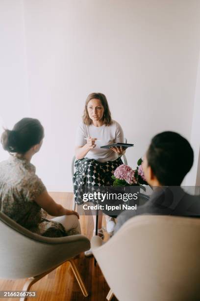 female psychotherapist in counseling and therapy session - terapia de pareja fotografías e imágenes de stock
