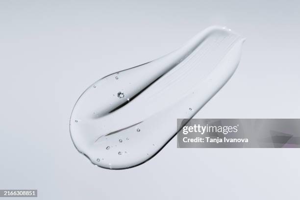 transparent smear liquid gel on gray background - dirty stock pictures, royalty-free photos & images