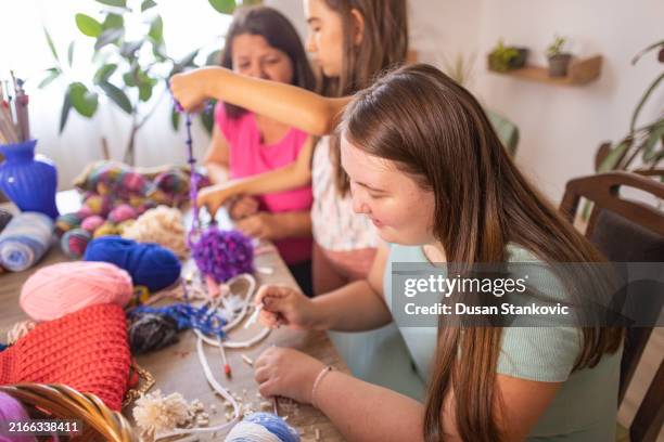 mother guides two daughters in knitting - art and craft stock pictures, royalty-free photos & images