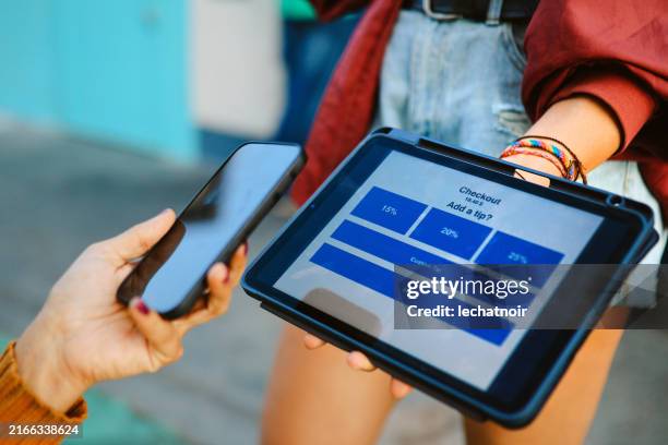 adding tip via digital tablet payment app in la, calilfornia - creditcardlezer stockfoto's en -beelden