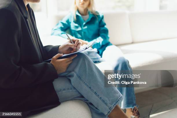 two women sitting in armchairs and talking. female coach, psychotherapist, psychologist, advisor and patient, client, psychotherapy, job interview - psicoterapeuta foto e immagini stock