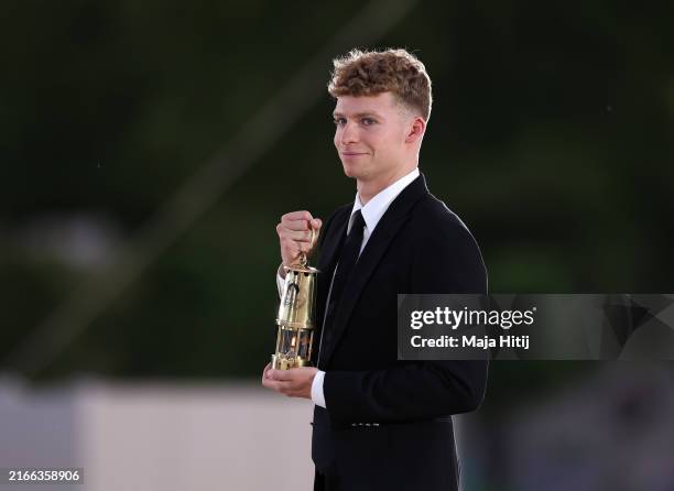 Leon Marchand of Team France carries the Olympic flame during the Closing Ceremony of the Olympic Games Paris 2024 at Stade de France on August 11,...