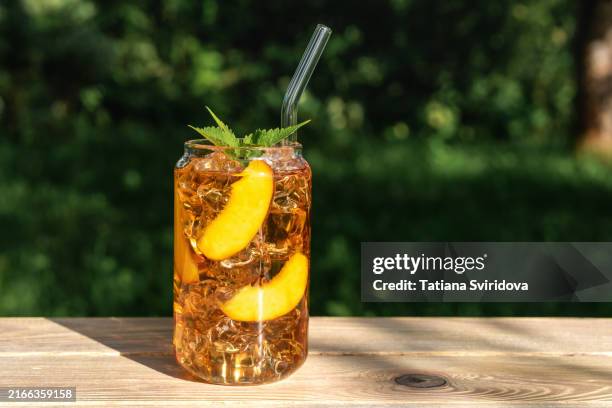glass of iced peach tea or mocktail drink - tea fotografías e imágenes de stock