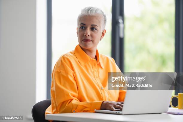 female business professional using laptop - grey hair stock pictures, royalty-free photos & images