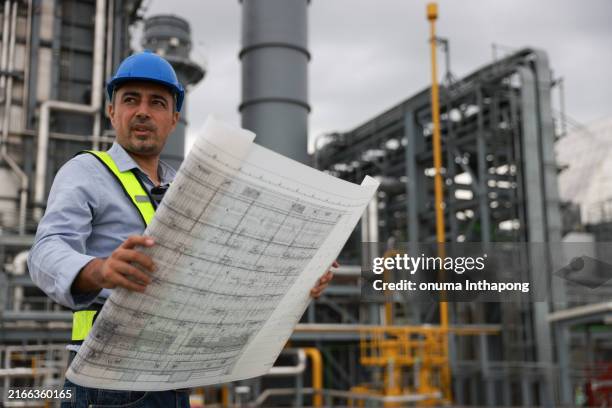 electrical engineers, holding blueprints, look confident at the thermal power plant while working on project planning to produce high-voltage electrical energy, emphasizing the energy concept. - factory blueprint stock pictures, royalty-free photos & images