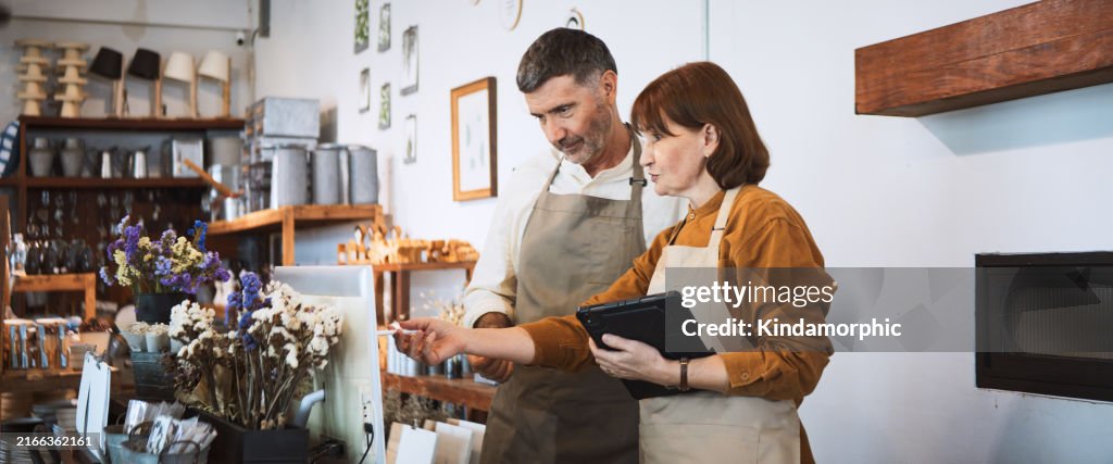 Casal branco sênior trabalha junto na própria loja de varejo de pequenas empresas. Discuta a conversa usando tablet digital, computador. Venda produtos de decoração de arte e artesanato. Pessoas de negócio adultas, conceito do empreendedor do SME