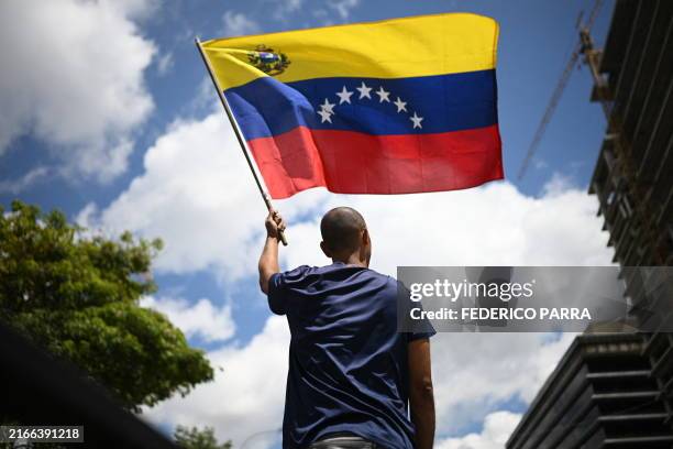 Man waves a Venezuelan flag during a protest called by the opposition for election 'victory' to be recognised, in Caracas on August 17, 2024....