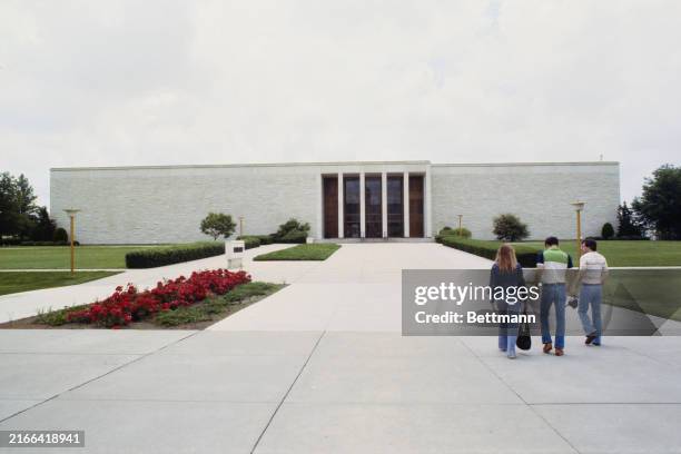 View of three people walking toward the Dwight D Eisenhower Presidential Library in Abeline, Kansas, June 6th 1978.