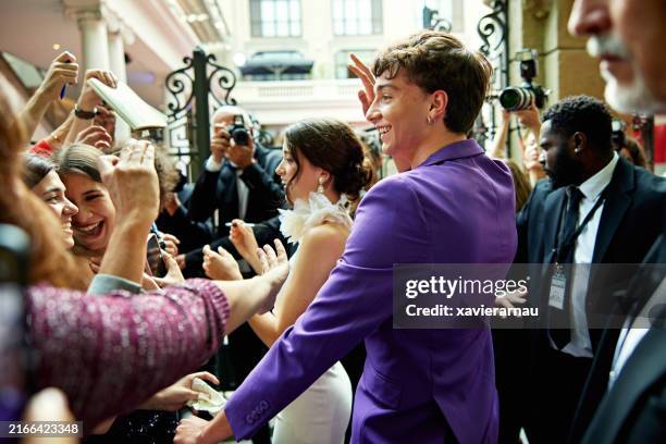 joven pareja de celebridades llegando a evento de entretenimiento - fama fotografías e imágenes de stock