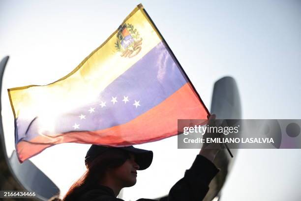 Woman waves a Venezuelan flag during a protest called by the Venezuelan opposition for election 'victory' to be recognised at the United Nations...