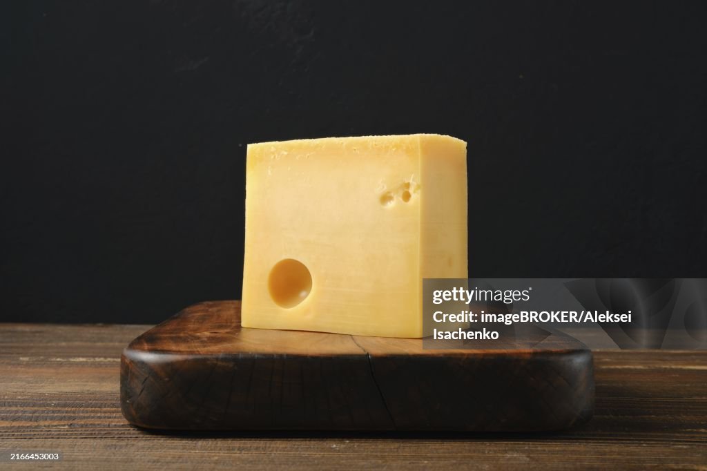 Block of Swiss cheese on cutting board