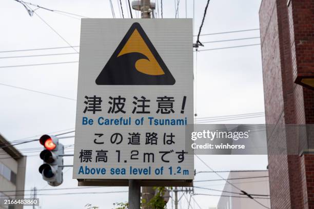 be careful of tsunami sign in hakodate, hokkaido, japan - tsunami evacuation route sign stock pictures, royalty-free photos & images