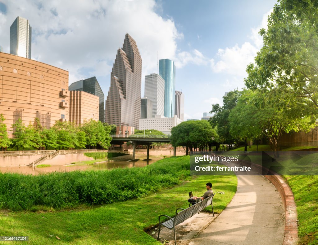 University Student working on laptop in city park