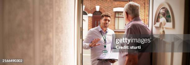 ratsbeamter unterhält sich mit dem älteren mieter - kundenwerber stock-fotos und bilder