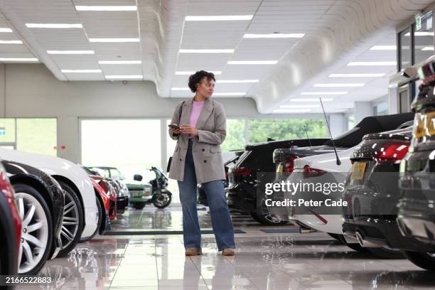 woman buying car in showroom - buying a car stock pictures, royalty-free photos & images