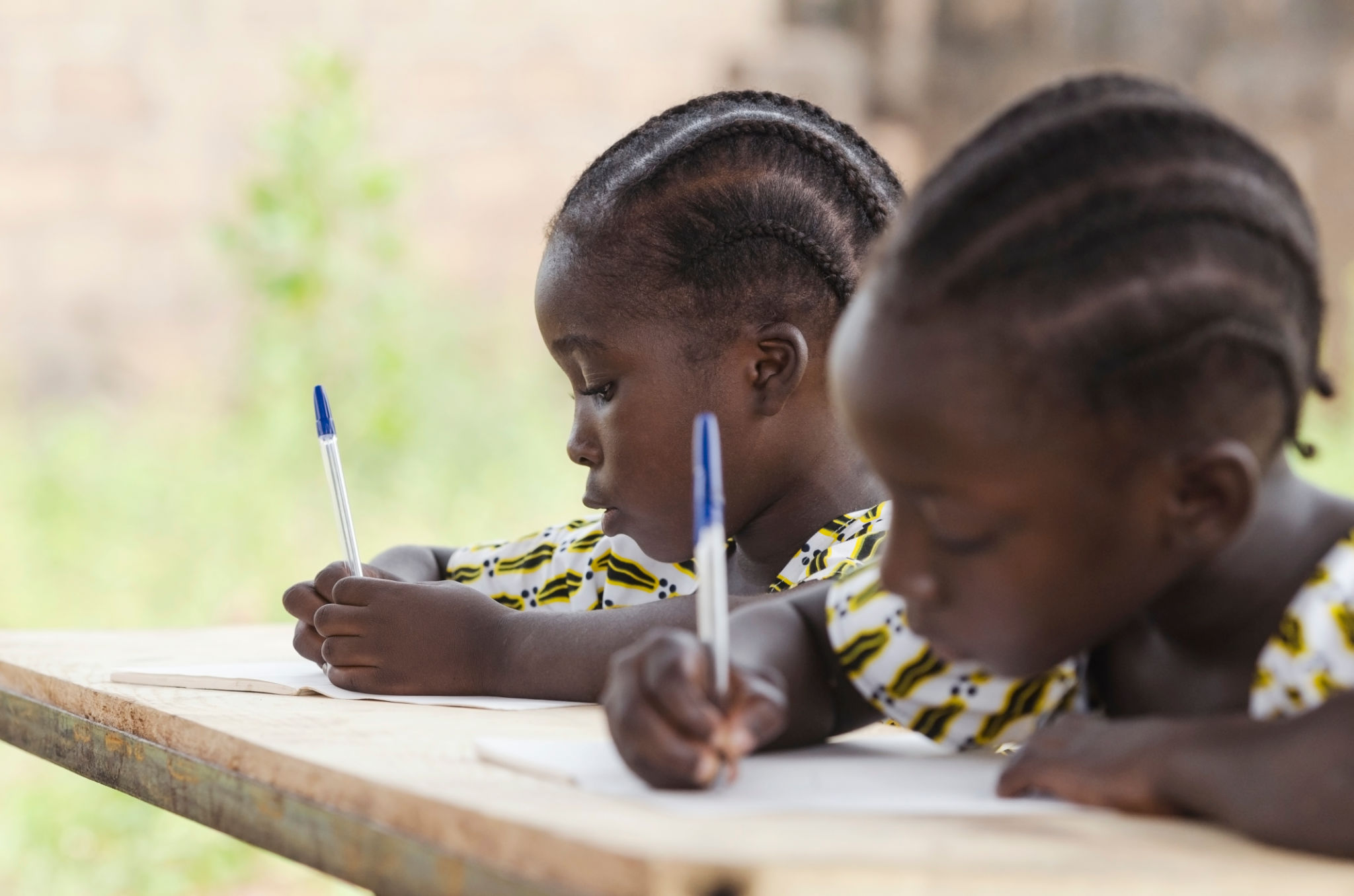 Close-Up Of Girls Writing In Book Close-Up Of Girls Writing In Book