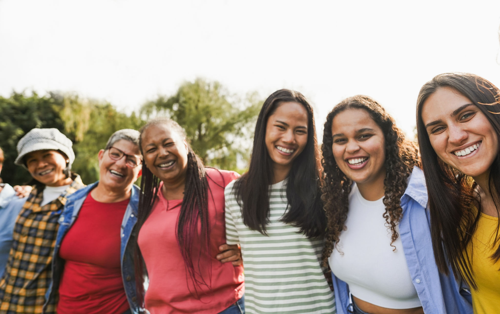 Multi generational women smiling in front of camera - Female multiracial group having fun togheter outdoor - Main focus on right girl face Multi generational women smiling in front of camera - Female multiracial group having fun togheter outdoor - Main focus on right girl face
